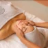 Uma mulher recebendo massagem facial na Sommos SPA