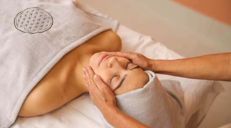 Uma mulher recebendo massagem facial na Sommos SPA